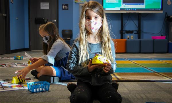 Girl smiles while holding BeeBot